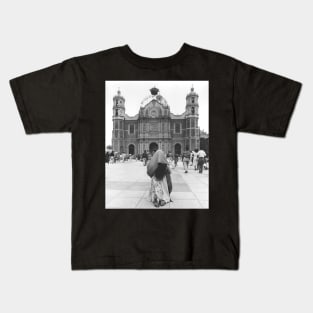 Woman Praying in front of Our Lady of Guadalupe Kids T-Shirt